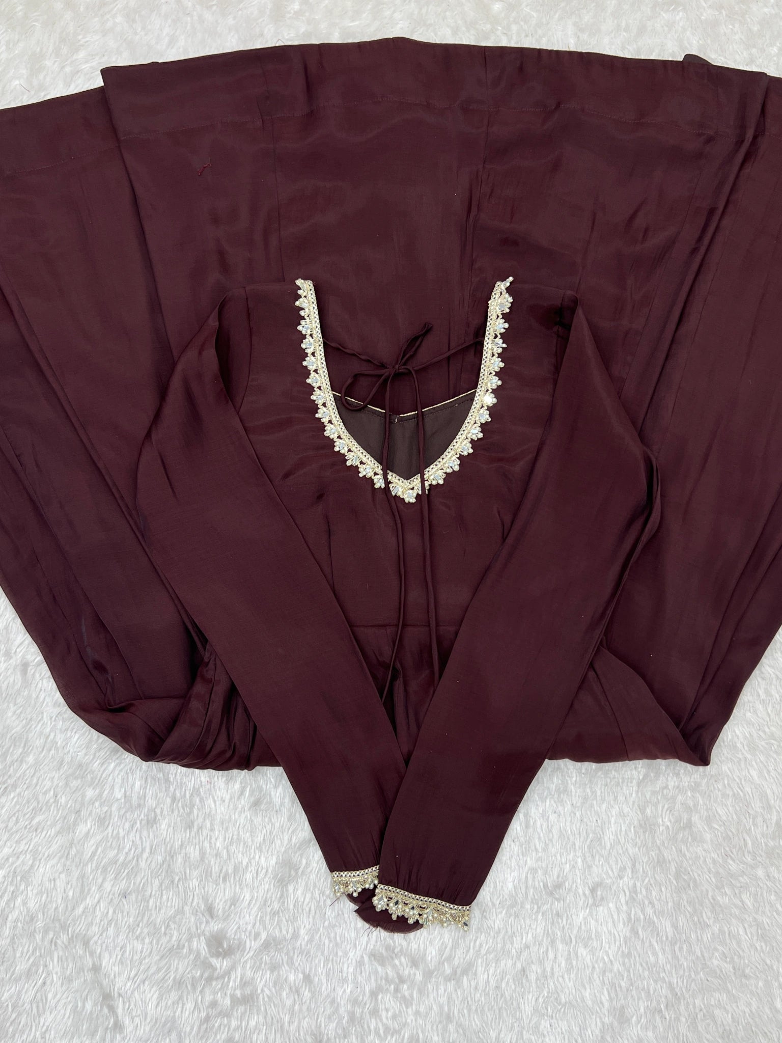 Dark Brown suit back neckline with dori tie and lace-trimmed sleeve cuff flat lay